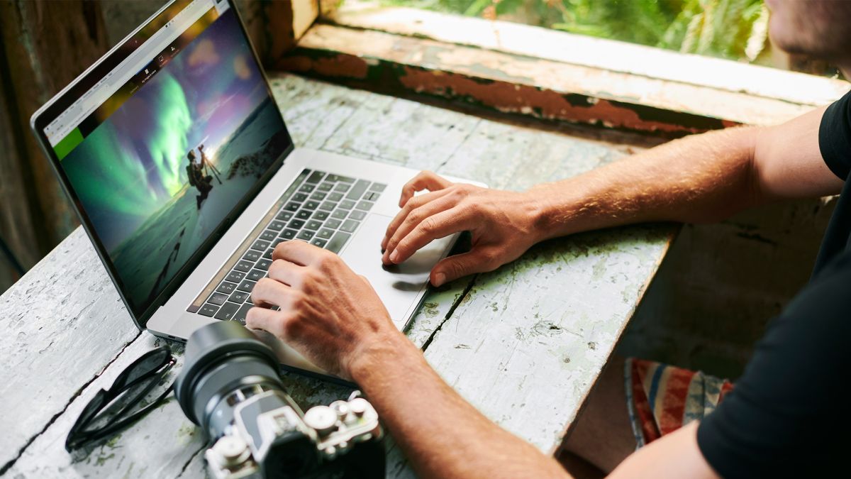 Man using one of the best photo editing apps on a laptop to edit astrophotographs
