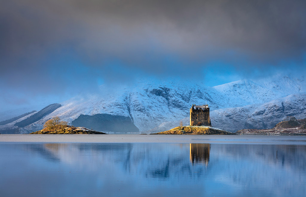 Castle Stalker, Scotland cloudy blue landscape reflecting in lake will davies